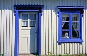 Weißes Holzhaus mit blauen Fenstern