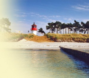 Leuchtturm "Luchte" im Süden der Insel Hiddensee mit elfenbeinfarbenem Sandstrand, Dünen, Kiefernwald - vom Wasser aus fotografiert.