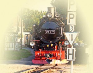 Lokomotive der historischen Schmalspurbahn Rasender Roland auf der Insel Rügen - am Bahnübergang mit Schiene