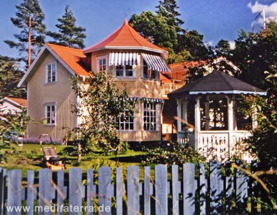 gelbes Holzhaus in Schweden mit Türmchen