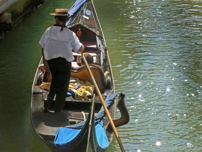 Gondoliere in Venedig - Gondel mit Menschen und Gondoliere mit Hut