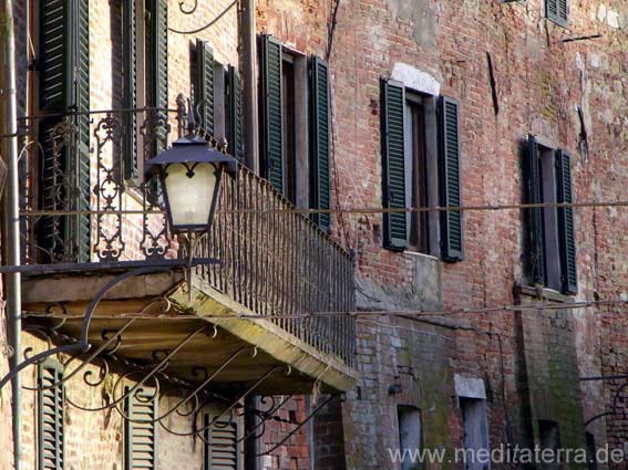 Schmiedeeiserner Balkon und alte Laterne an einem Toskana-Haus in Montepulciano - Nähe Stadtmauer