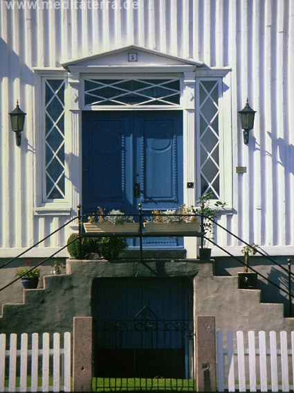 Blaue Haustür an einem weißen Holzhaus in Norwegen