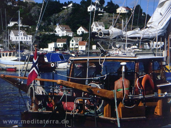 Blaues Meer mit Segelyacht und weißen Häusern in Norwegen