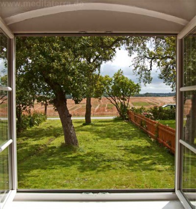 Offenes Fenster mit Blick auf Garten und Landschaft